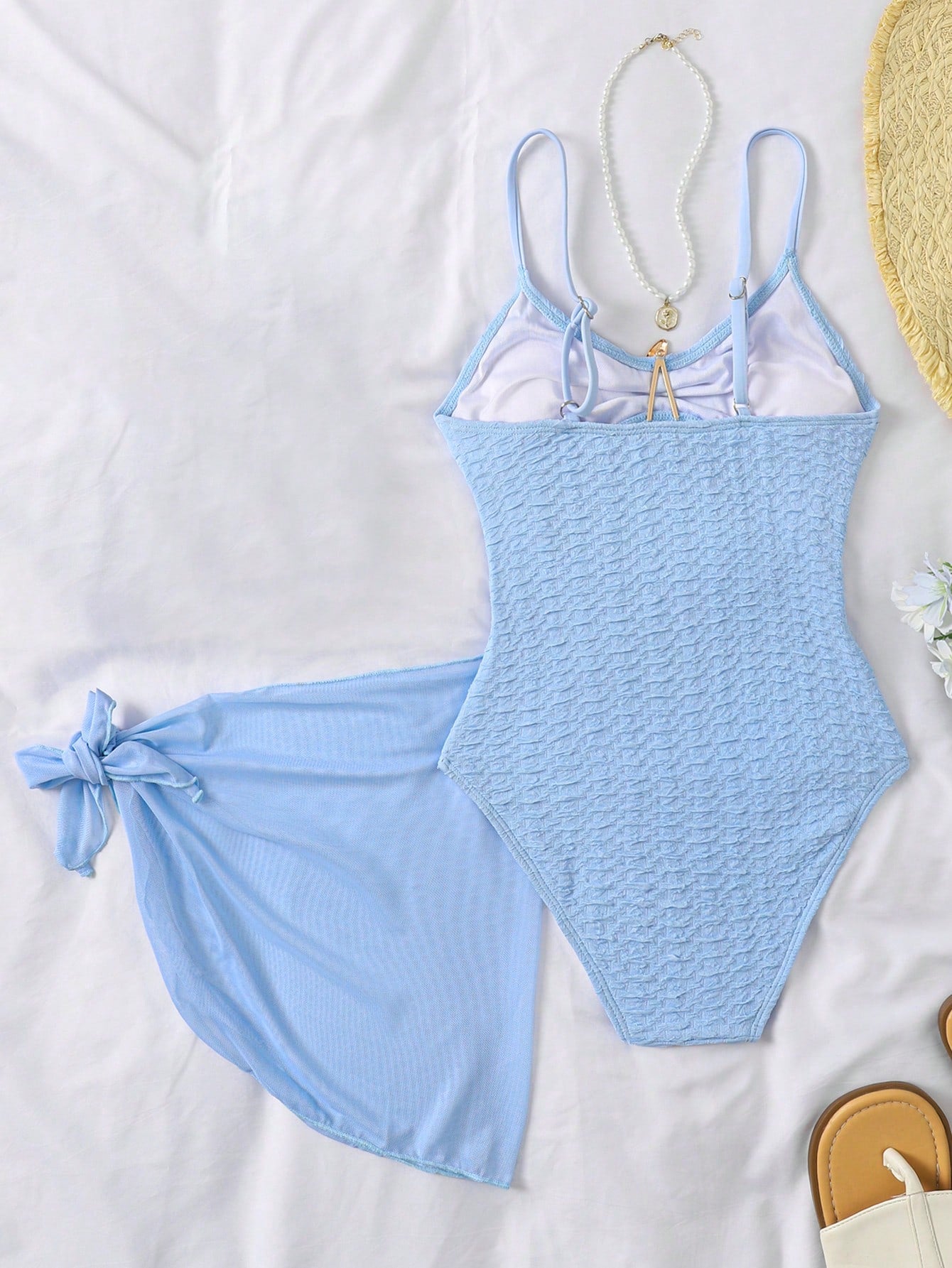 Baby blue tween girls one-piece swimsuit with textured metallic starfish decor, spaghetti straps, ruched fitted body, and short apron-style skirt cover-up