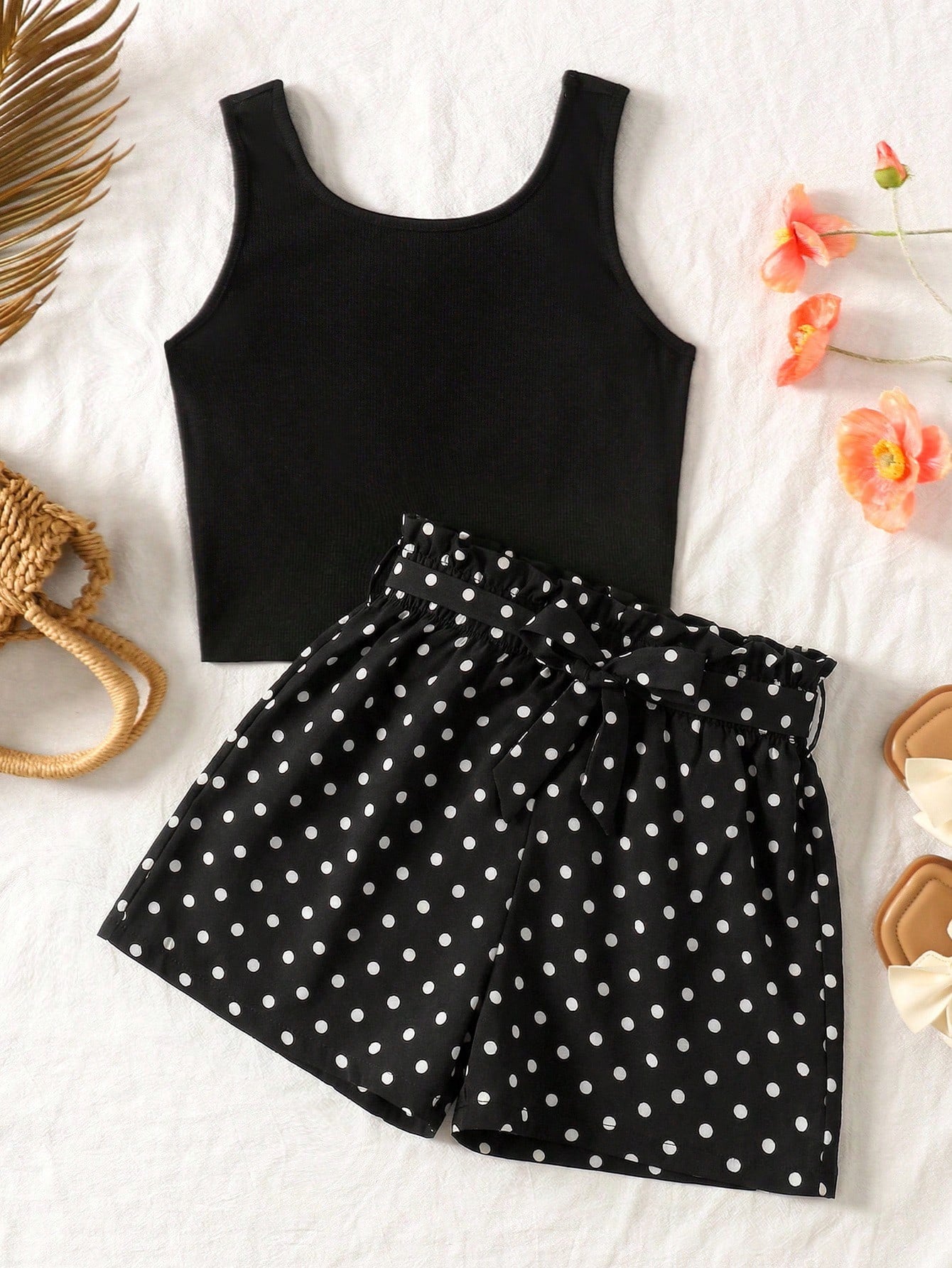 Tween girl wearing a casual 2-piece set featuring a black rib-knit scoop neck tank top and leopard print paperbag waist shorts with a matching belt.