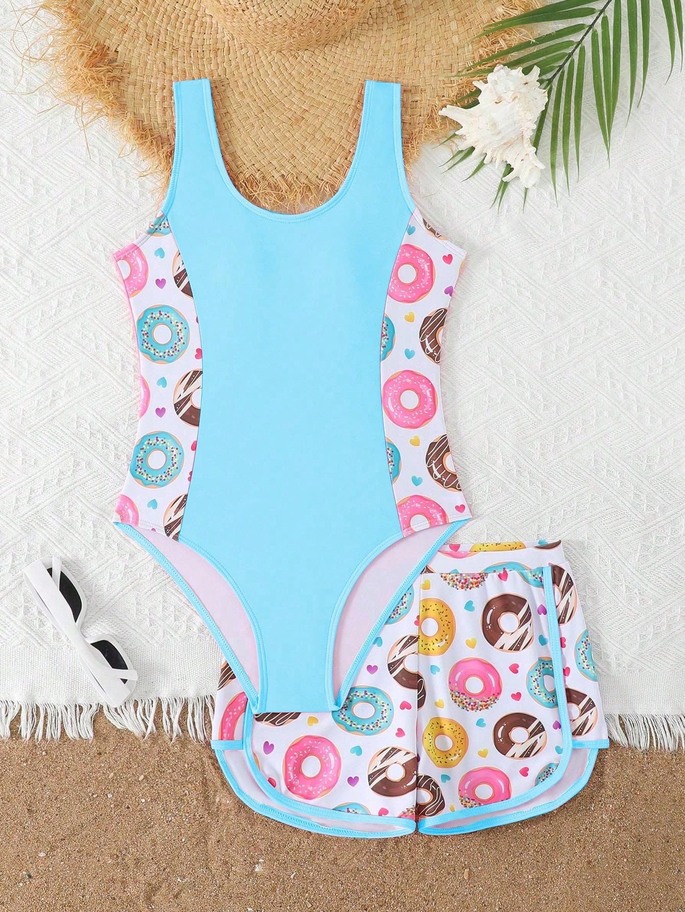 Tween girls 2-piece swimsuit set in black with full floral and plant print, featuring a sleeveless scoop-neck swim top and matching shorts-style bottoms.