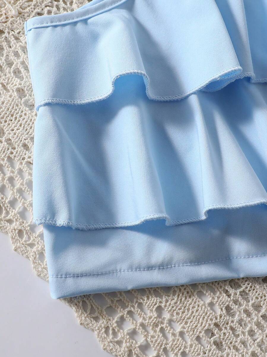 Tween girls blue 2-piece vacation outfit set featuring a tiered ruffle spaghetti strap camisole and loose high-waist pants.