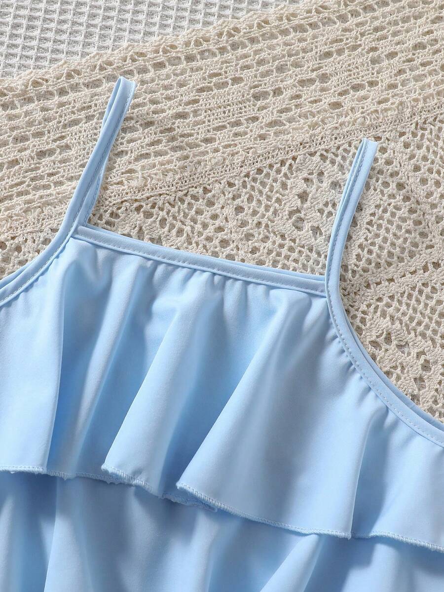 Tween girls blue 2-piece vacation outfit set featuring a tiered ruffle spaghetti strap camisole and loose high-waist pants.