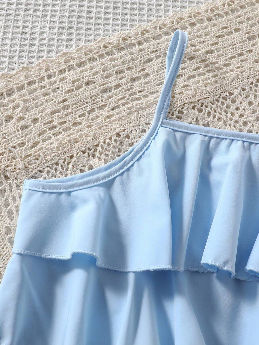 Tween girls blue 2-piece vacation outfit set featuring a tiered ruffle spaghetti strap camisole and loose high-waist pants.