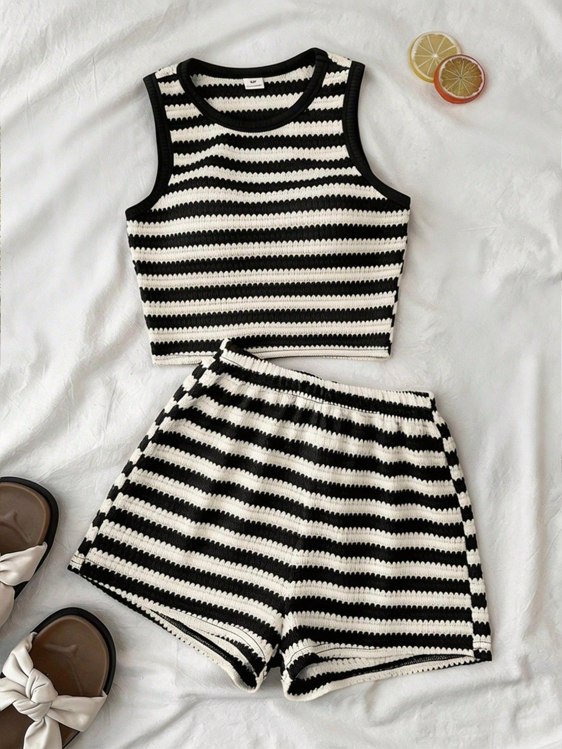 Tween girls black and white two-piece casual summer outfit featuring a rib-knit cropped top with round neck and matching shorts with contrast piping.
