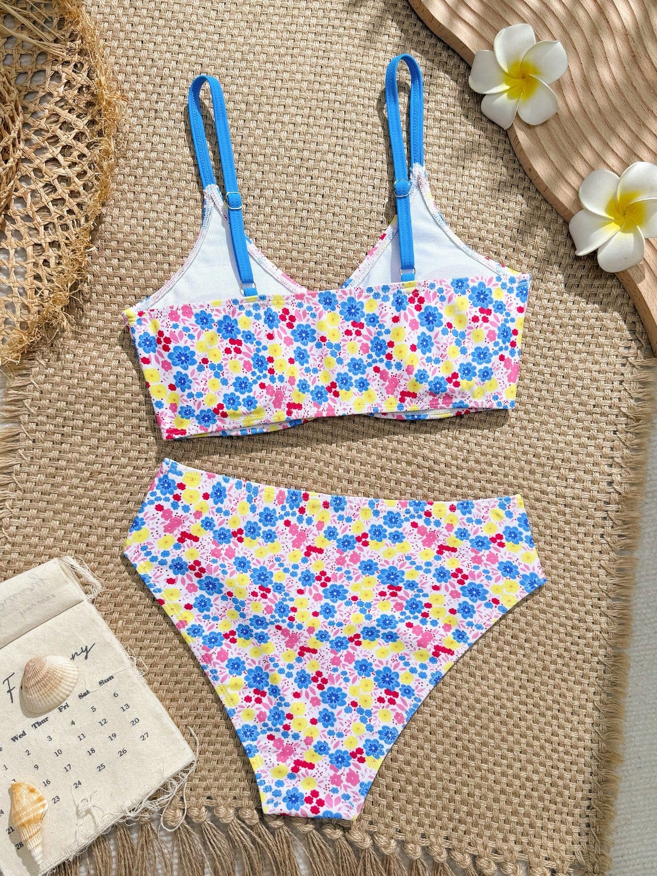 Tween girls 2-piece ditsy floral bikini set featuring a spaghetti strap top with center string detail and matching bottoms with side strings, designed for swimming, vacation, and summer wear.