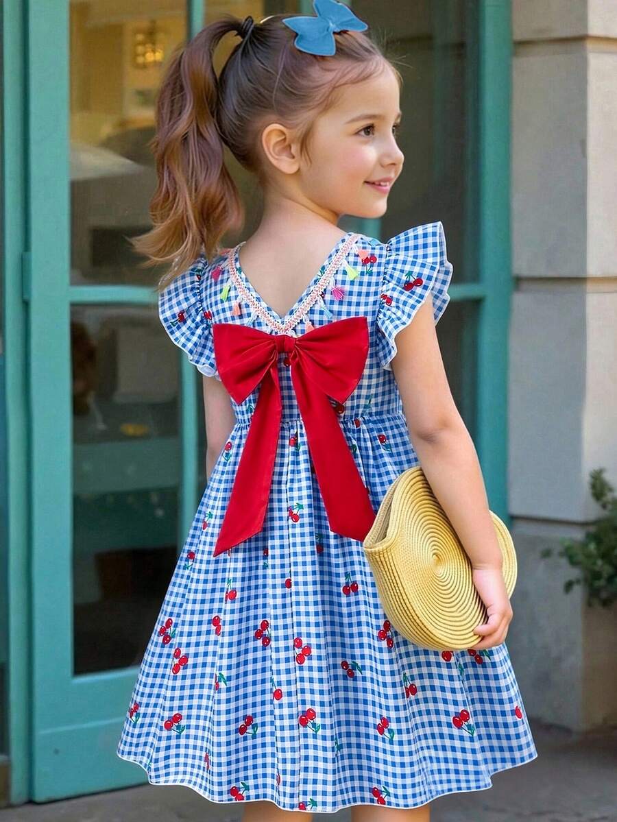 Tween girls blue short smock dress featuring flounce short sleeves, high waist flared hem, round neck, and front bow detail.