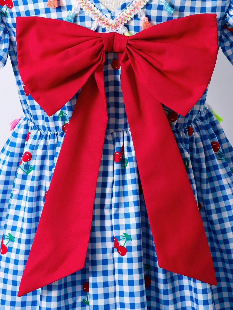 Tween girls blue short smock dress featuring flounce short sleeves, high waist flared hem, round neck, and front bow detail.