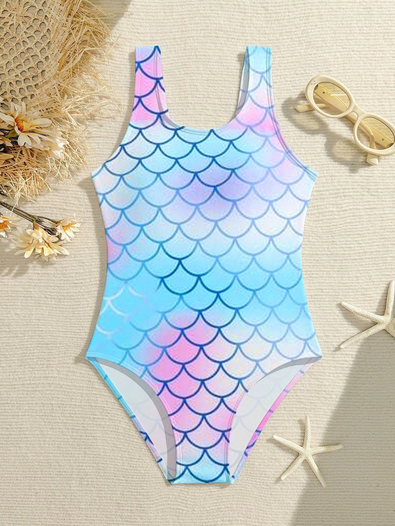 Tween girls one-piece swimsuit with a black base and multicolor tropical plant print featuring bamboo, palm leaves, plumeria flowers, scoop neck, and wide straps.