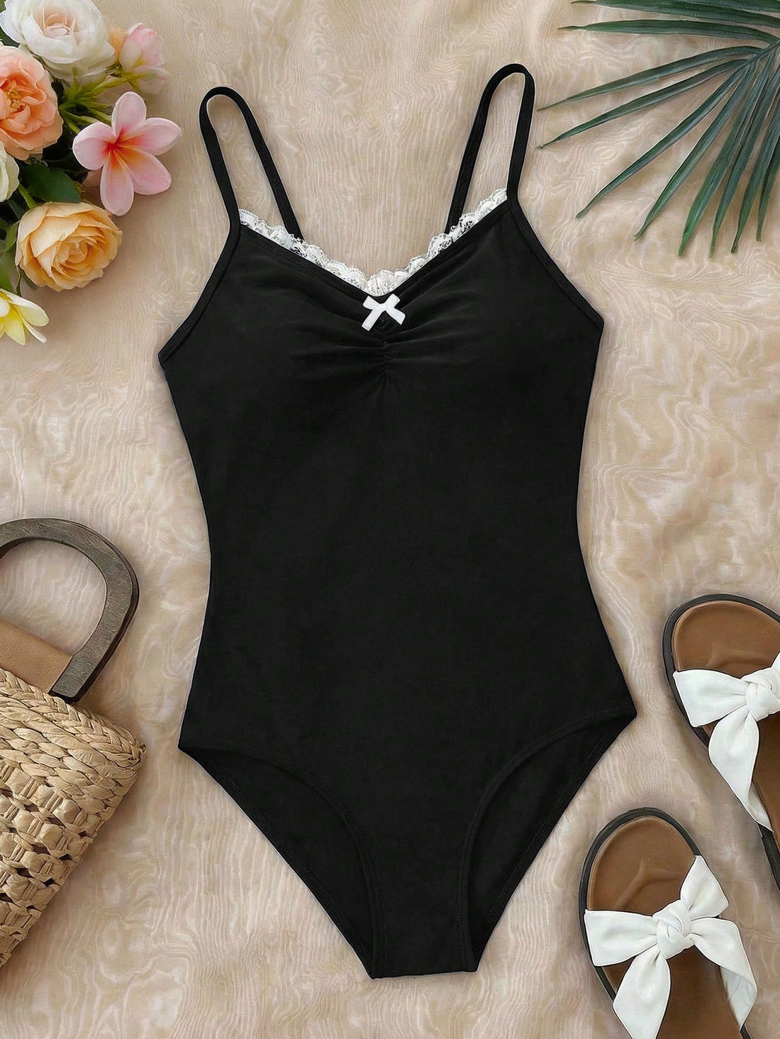 Tween girls' one-piece swimsuit featuring a ruffle splice front, ruched detailing, bow accent, contrast lace trim, and spaghetti straps.
