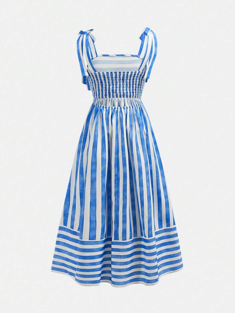 Tween girls blue striped summer camisole dress featuring spaghetti straps, high waist, flared hem, and back zipper detail.