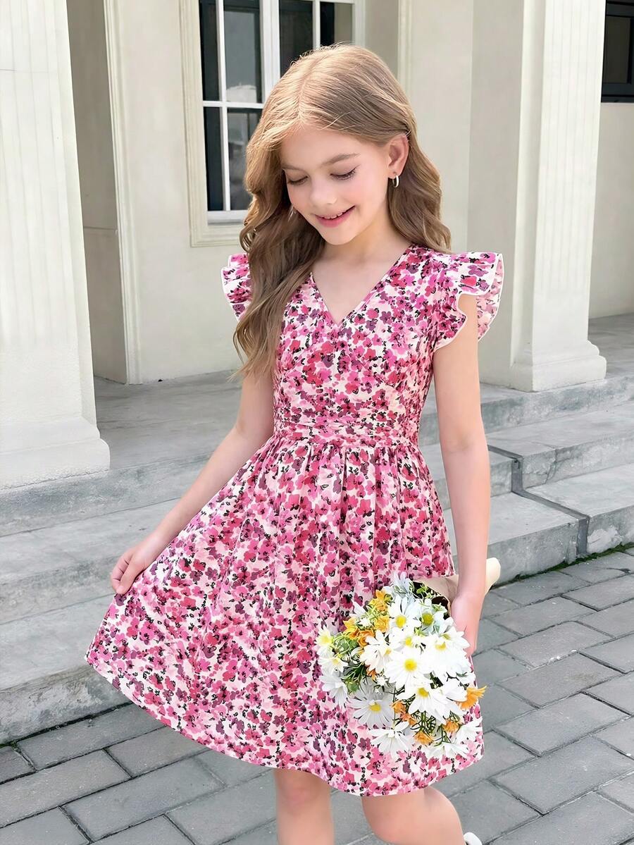 Tween girl wearing a black ditsy floral A-line short dress with V-neckline and flounce short sleeves.