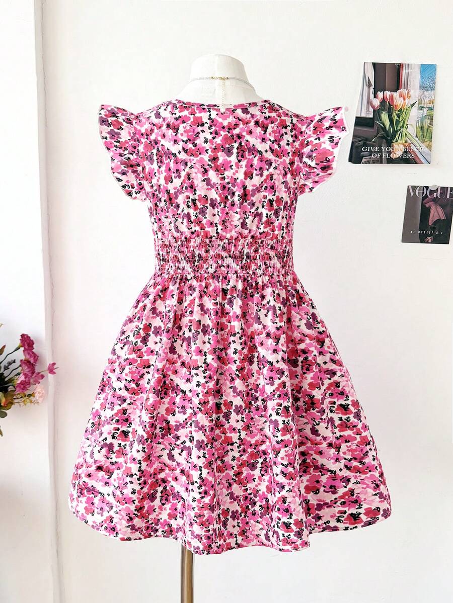 Tween girl wearing a black ditsy floral A-line short dress with V-neckline and flounce short sleeves.