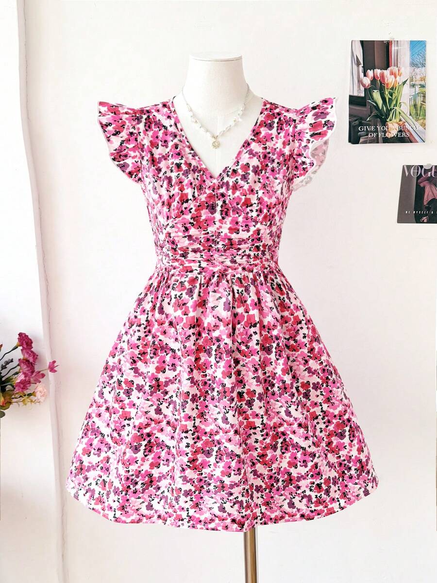 Tween girl wearing a black ditsy floral A-line short dress with V-neckline and flounce short sleeves.