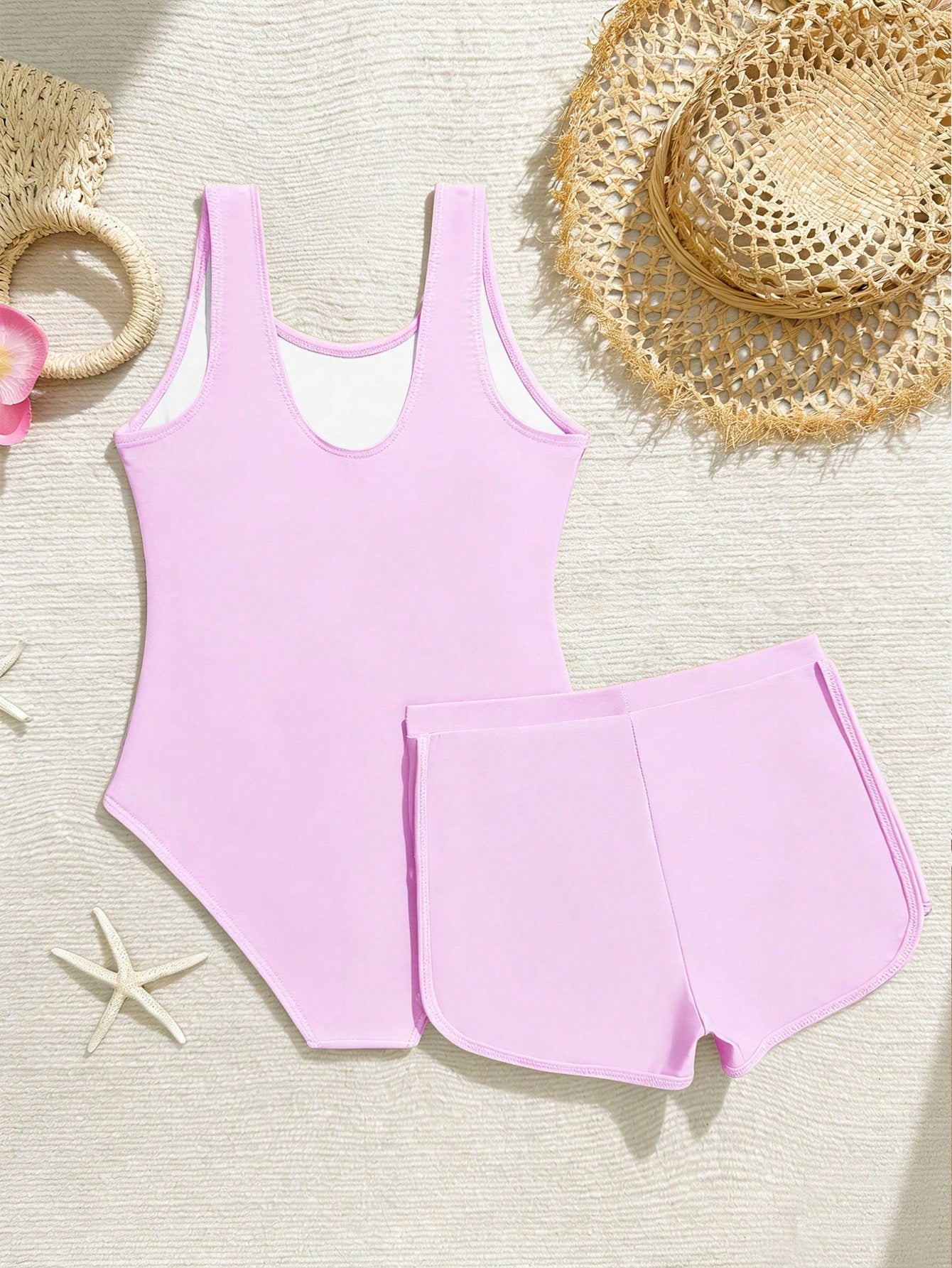 Tween girls 2-piece swimsuit set in black with full floral and plant print, featuring a sleeveless scoop-neck swim top and matching shorts-style bottoms.