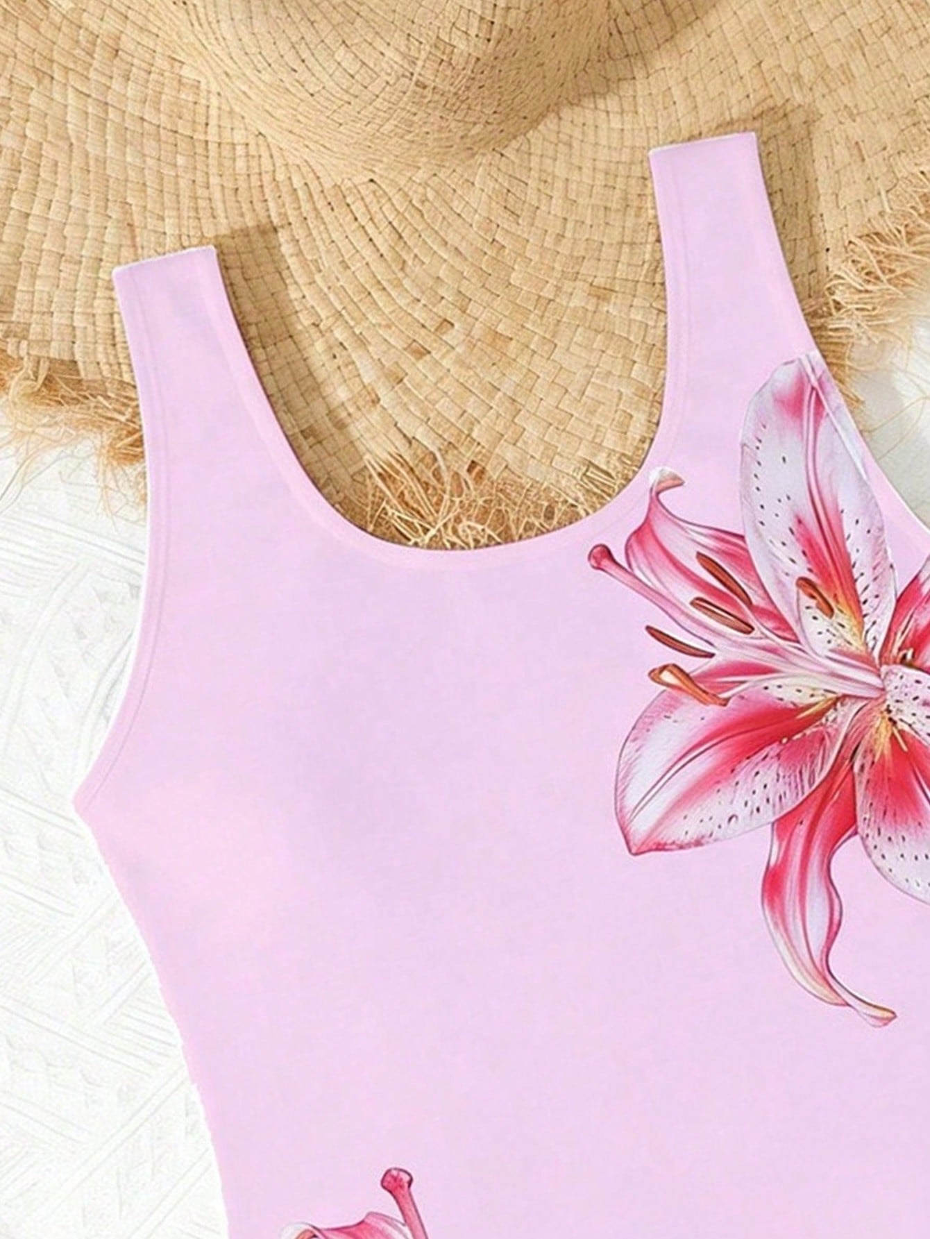 Tween girls 2-piece swimsuit set in black with full floral and plant print, featuring a sleeveless scoop-neck swim top and matching shorts-style bottoms.