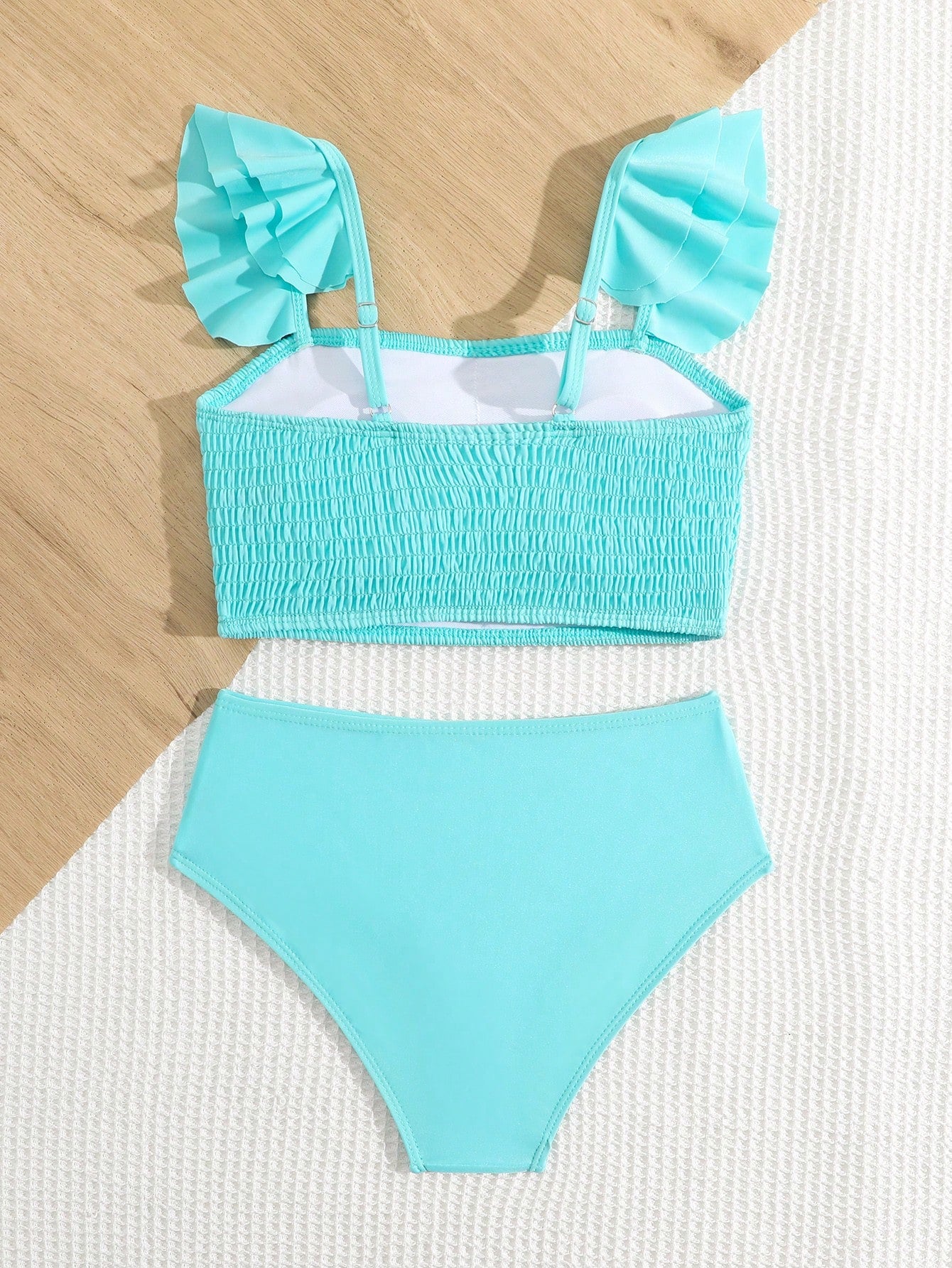 Tween girls tankini swimwear set with a solid color cap sleeve top featuring strap neckline and ruffle detail, paired with triangle-style briefs in a high-waist to mid-waist fit; two-piece vacation swim set.