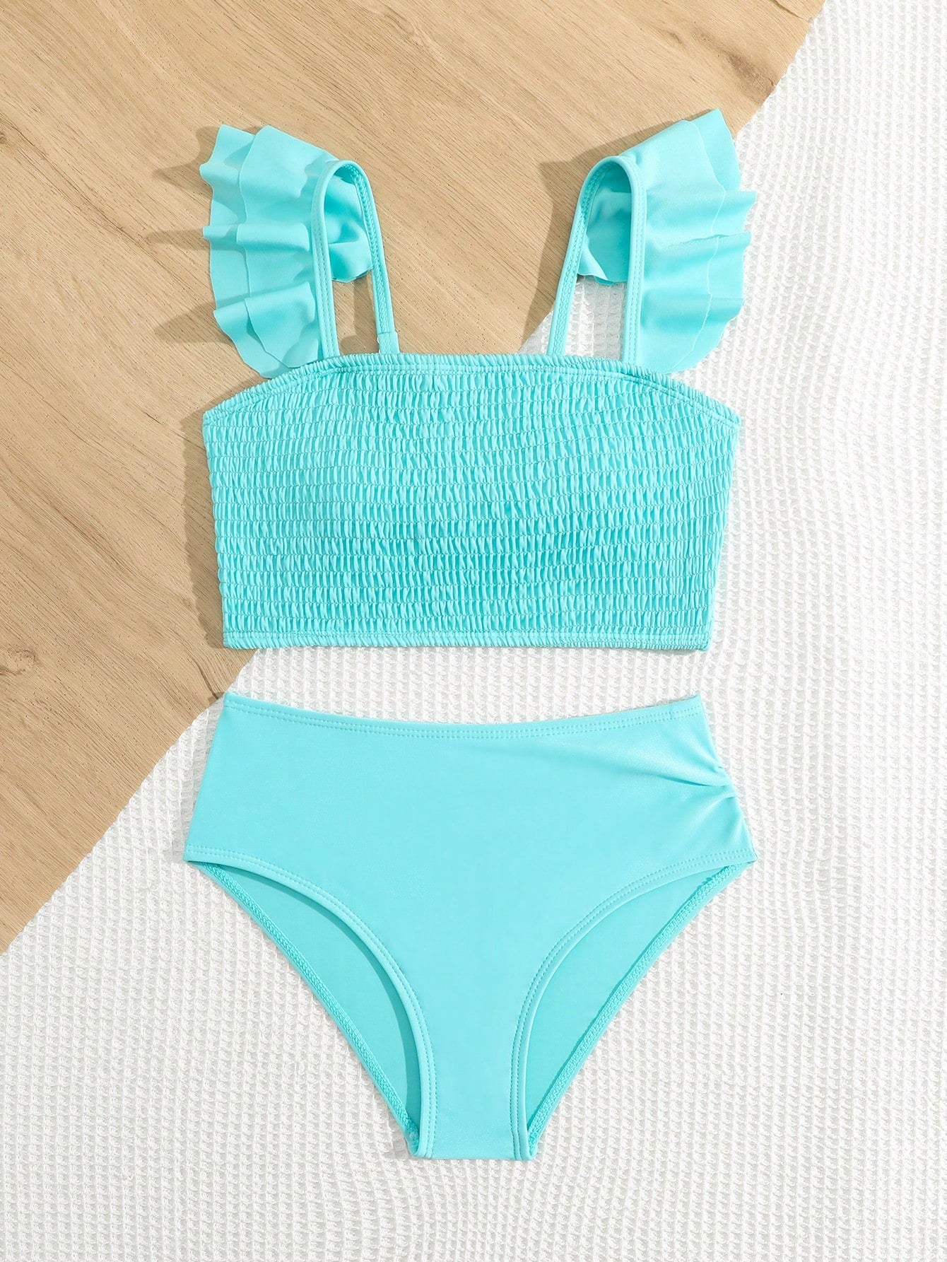 Tween girls tankini swimwear set with a solid color cap sleeve top featuring strap neckline and ruffle detail, paired with triangle-style briefs in a high-waist to mid-waist fit; two-piece vacation swim set.