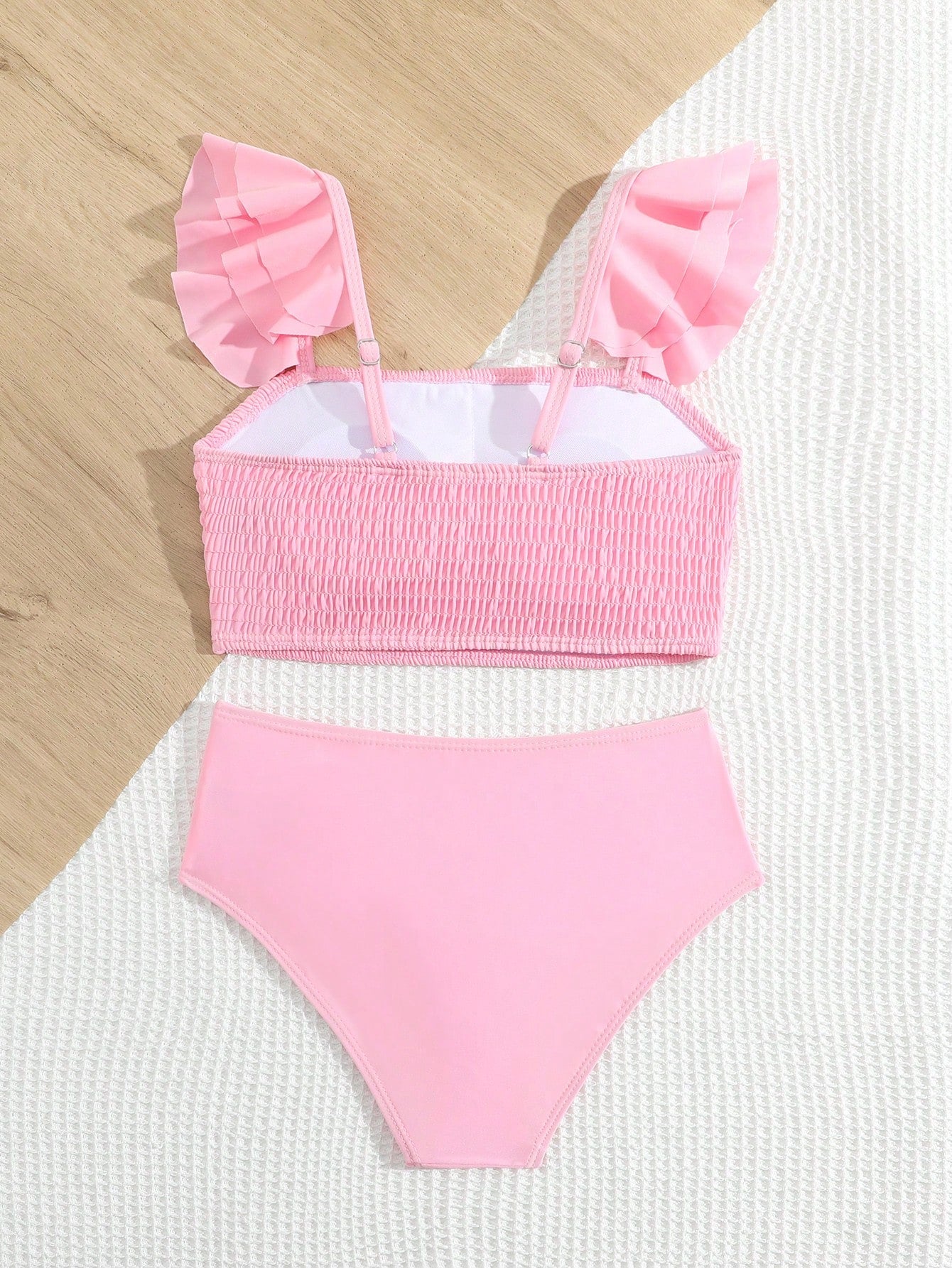 Tween girls tankini swimwear set with a solid color cap sleeve top featuring strap neckline and ruffle detail, paired with triangle-style briefs in a high-waist to mid-waist fit; two-piece vacation swim set.