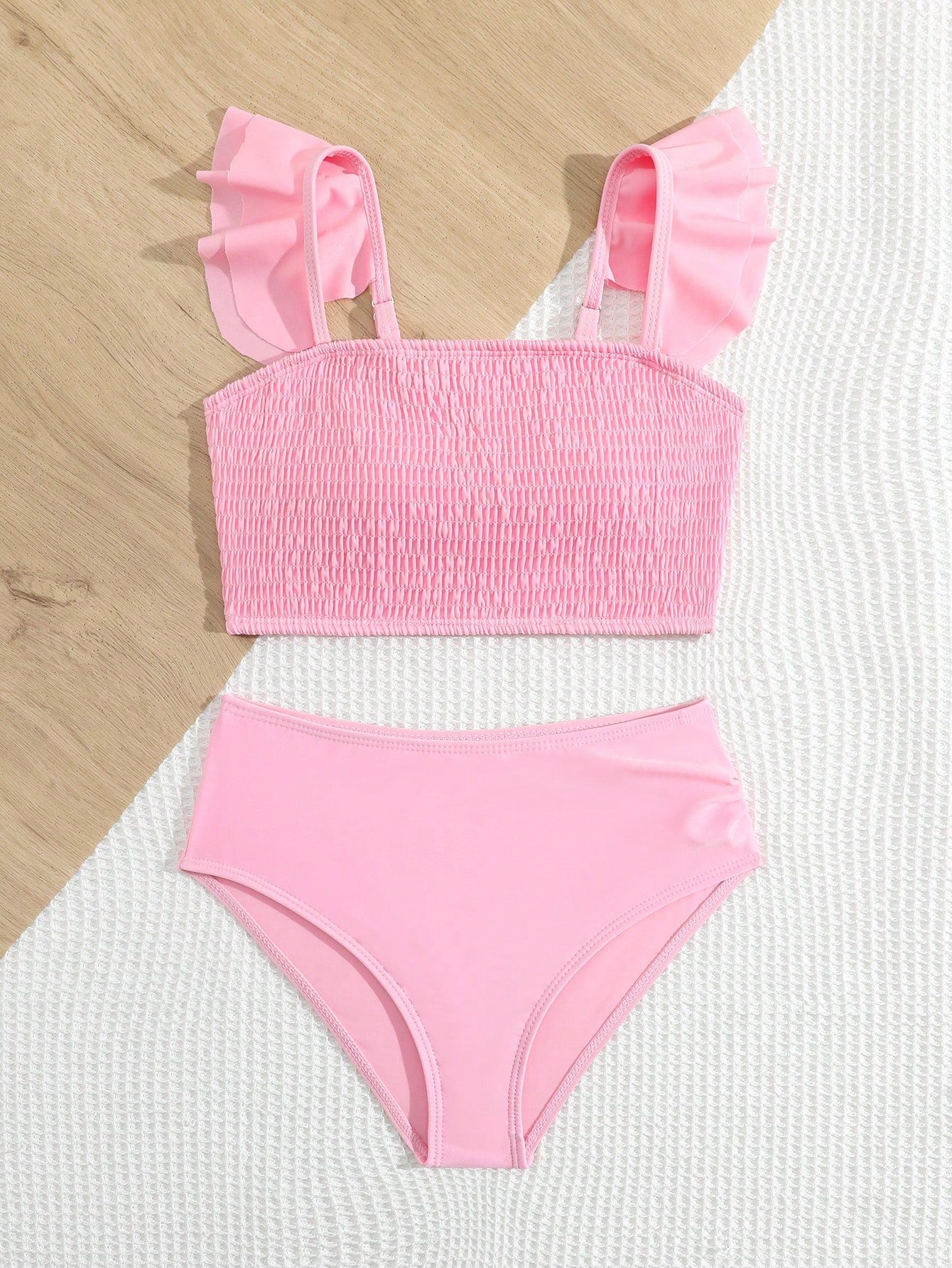Tween girls tankini swimwear set with a solid color cap sleeve top featuring strap neckline and ruffle detail, paired with triangle-style briefs in a high-waist to mid-waist fit; two-piece vacation swim set.