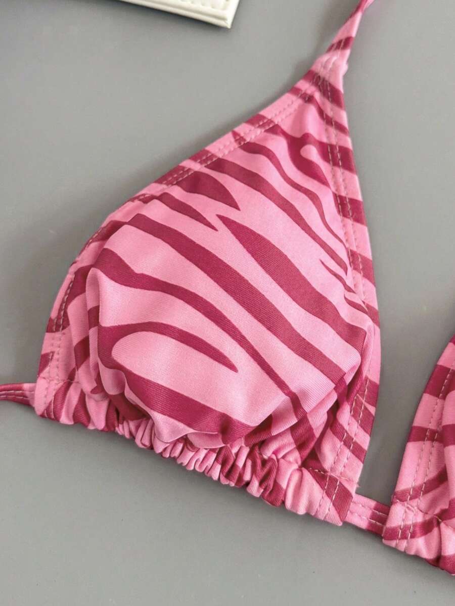 Women's black and white zebra print two-piece bikini set featuring a high waist tie-side bottom and a backless halter top with removable padding.