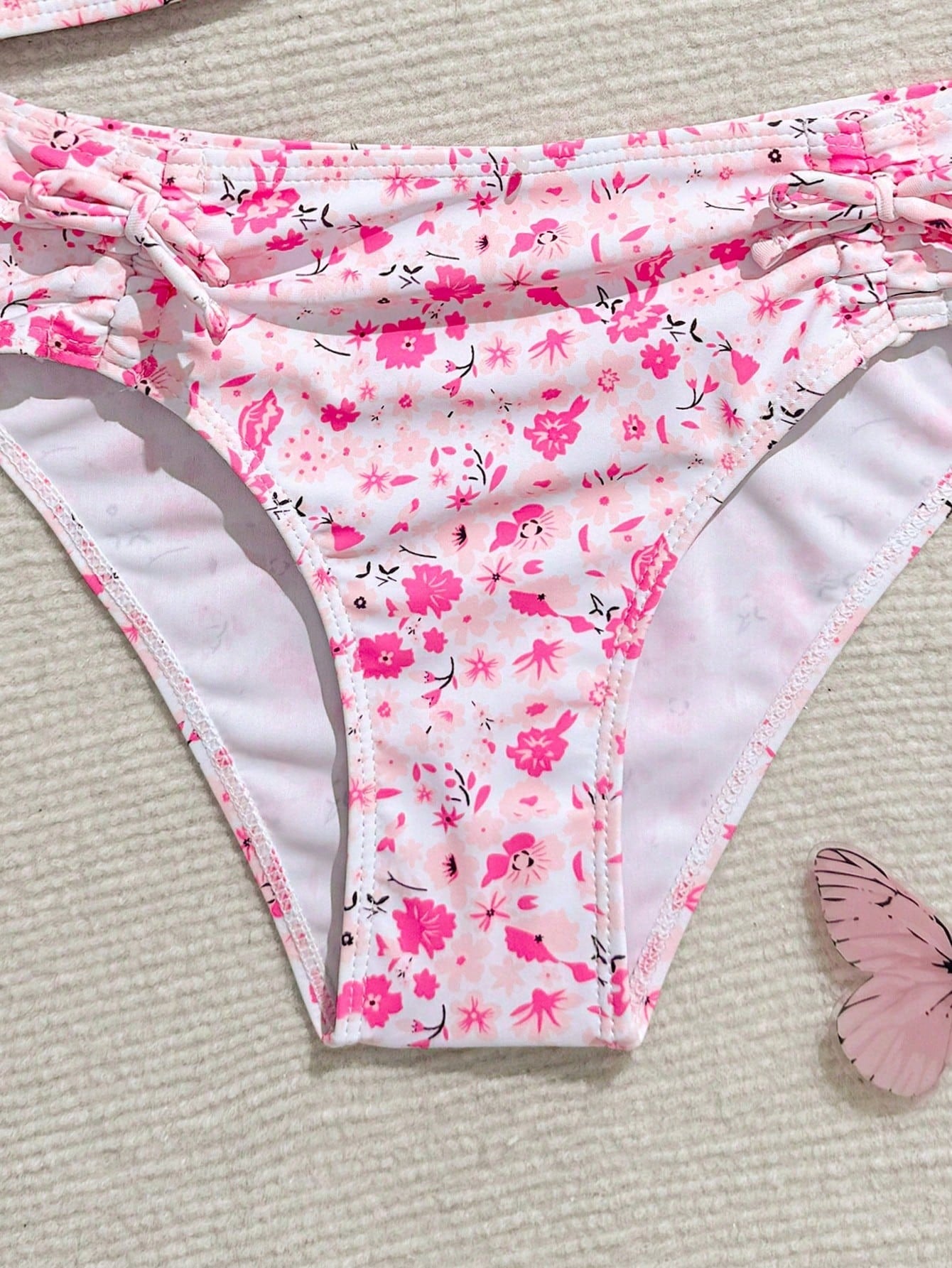 Tween girls 2-piece ditsy floral bikini set featuring a spaghetti strap top with center string detail and matching bottoms with side strings, designed for swimming, vacation, and summer wear.
