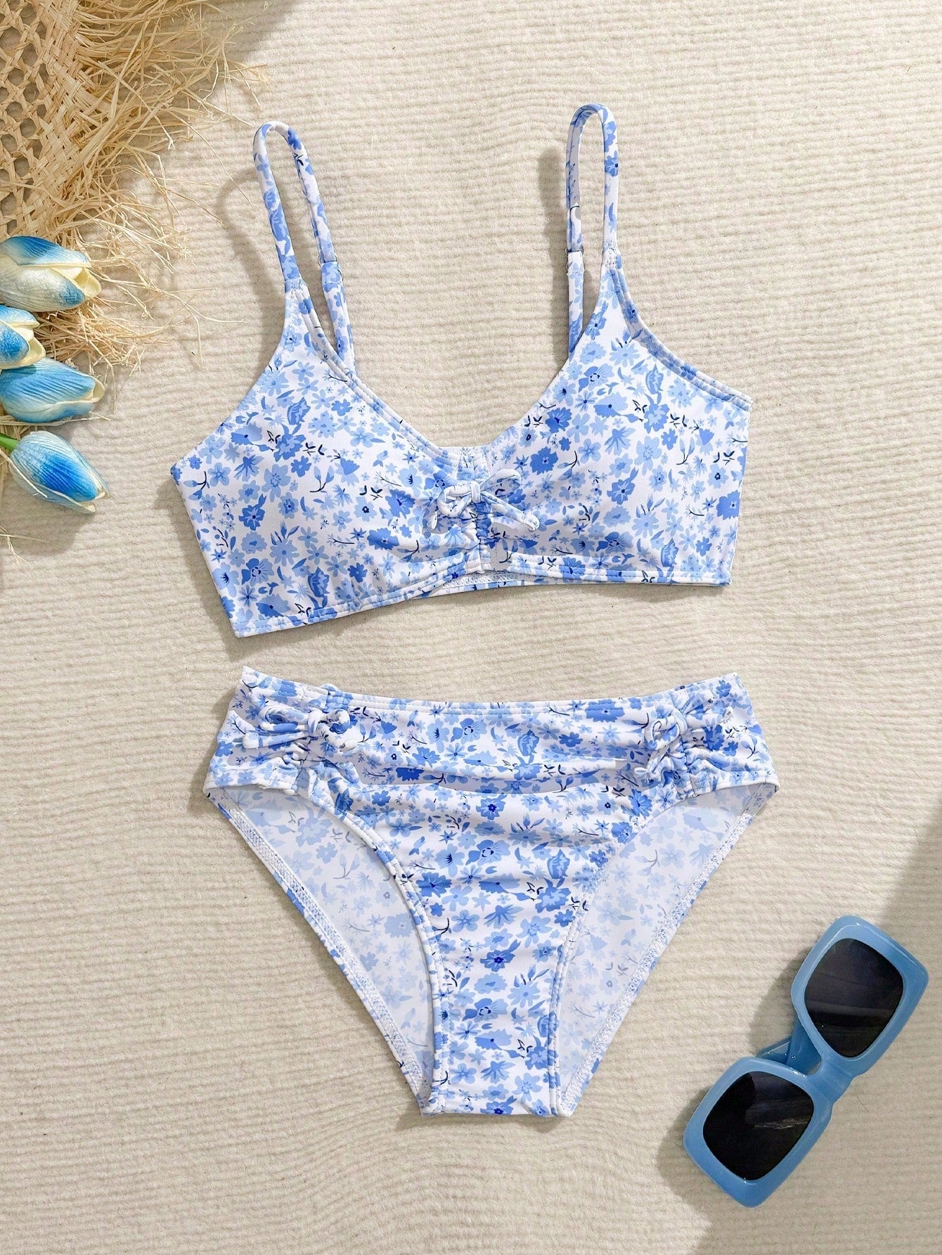 Tween girls 2-piece ditsy floral bikini set featuring a spaghetti strap top with center string detail and matching bottoms with side strings, designed for swimming, vacation, and summer wear.