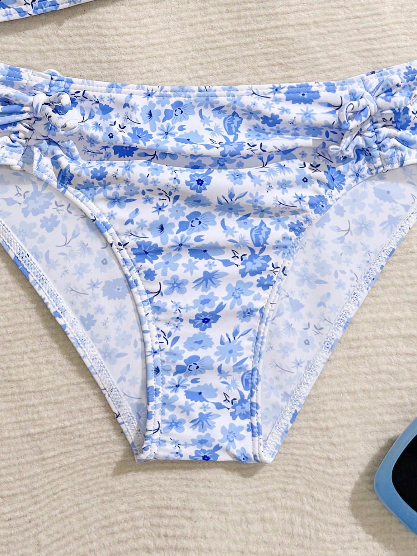 Tween girls 2-piece ditsy floral bikini set featuring a spaghetti strap top with center string detail and matching bottoms with side strings, designed for swimming, vacation, and summer wear.