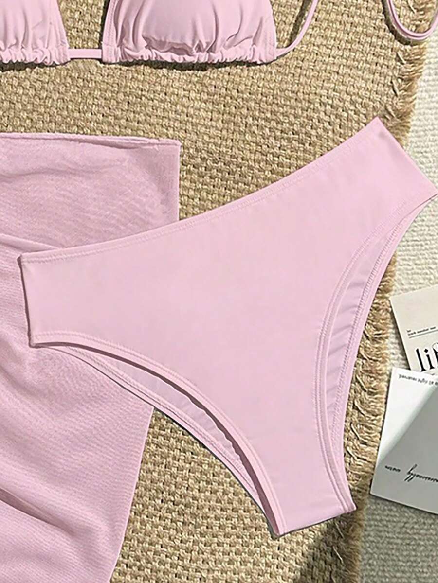 Pink 3-piece boho bikini set featuring a wireless triangle halter top with knot lace up detail and high waist bikini bottoms with matching skirt.