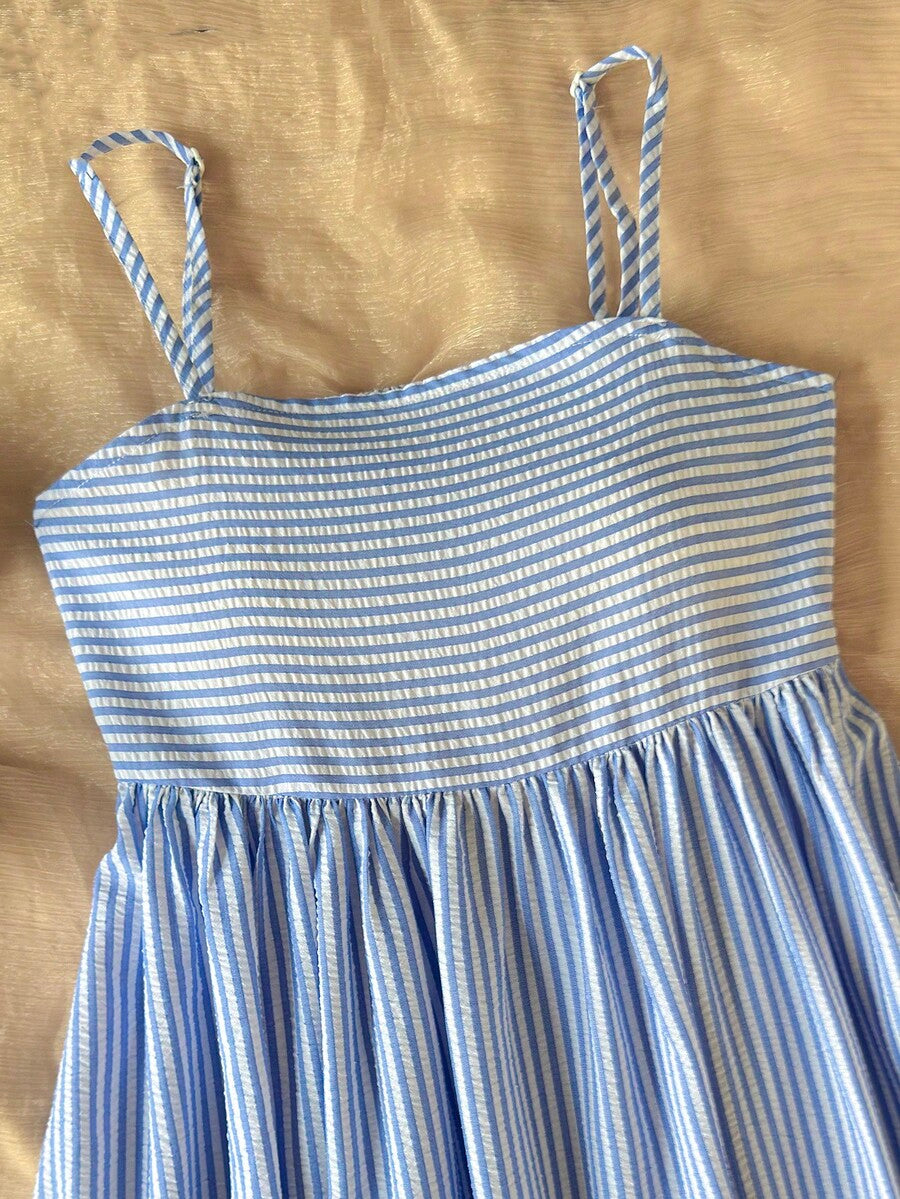 Tween girls blue striped summer camisole dress featuring spaghetti straps, high waist, flared hem, and back zipper detail.