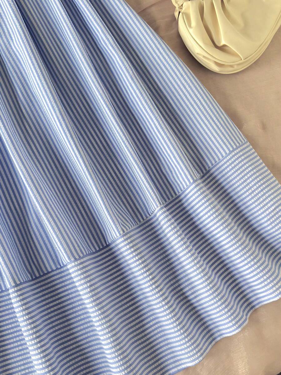 Tween girls blue striped summer camisole dress featuring spaghetti straps, high waist, flared hem, and back zipper detail.