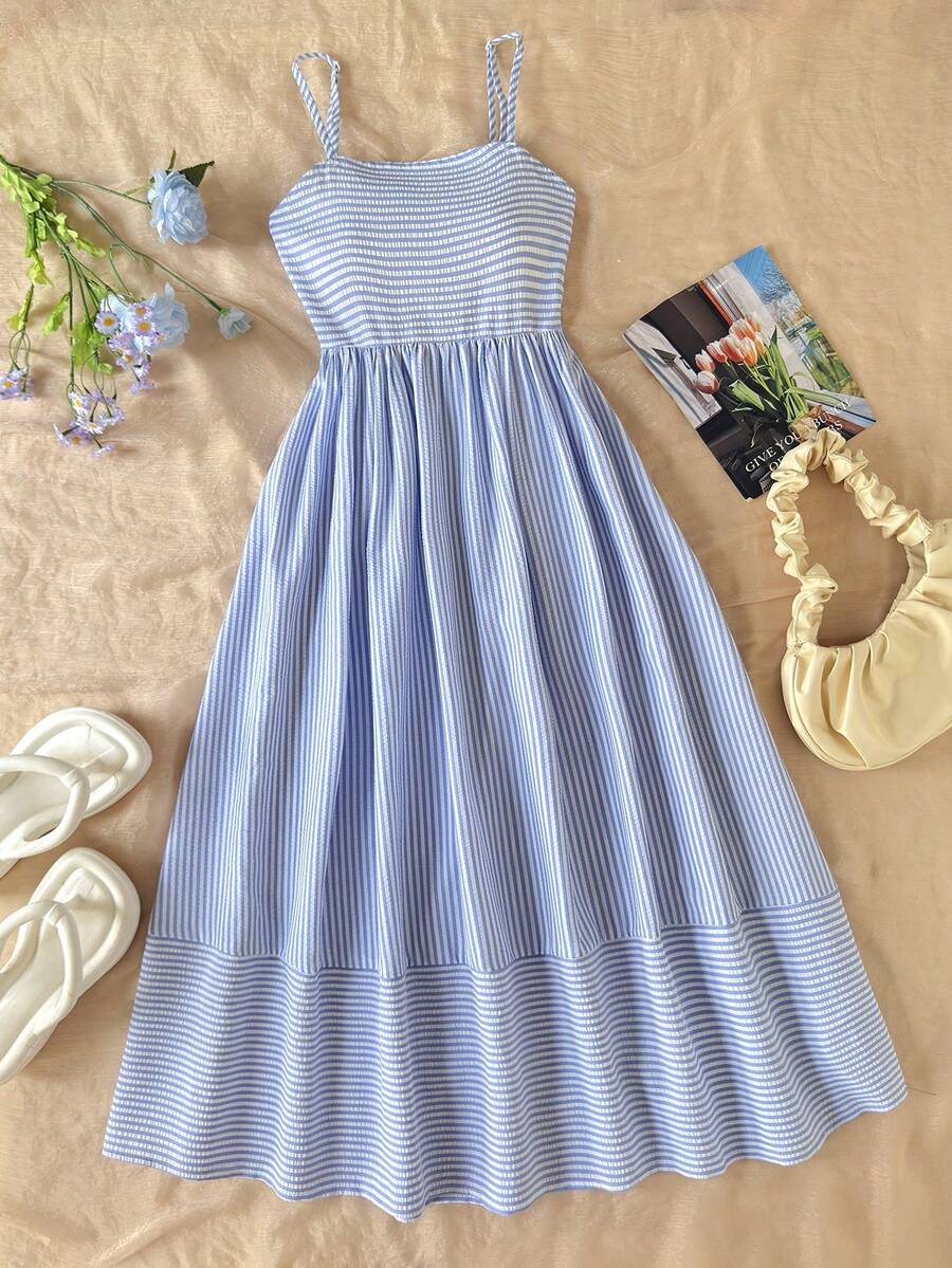 Tween girls blue striped summer camisole dress featuring spaghetti straps, high waist, flared hem, and back zipper detail.