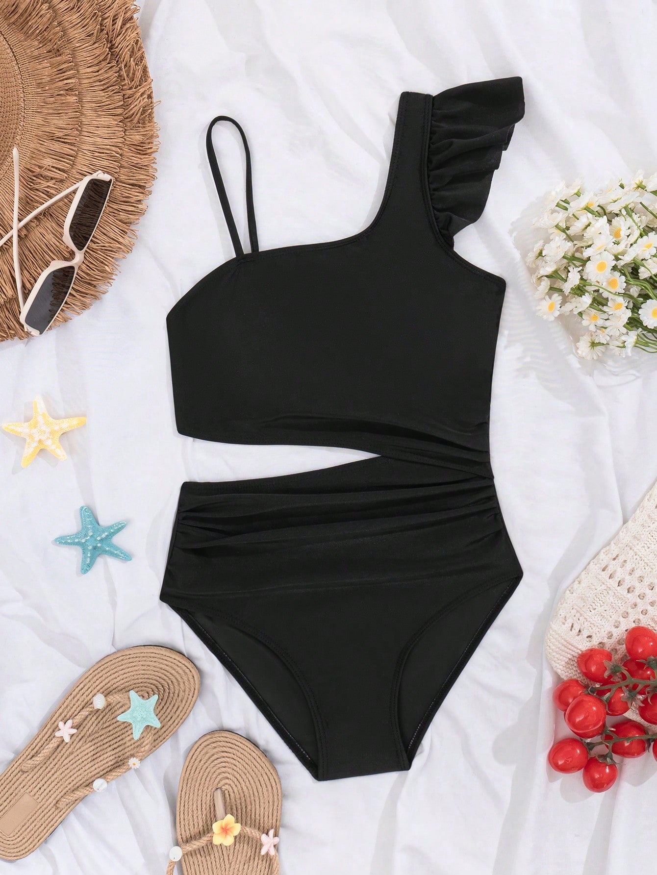 Tween girl one-piece swimsuit in brown polka dot geometric print with asymmetrical neckline, ruffle detail, cut-out design, and fitted mid-waist swim bottom.