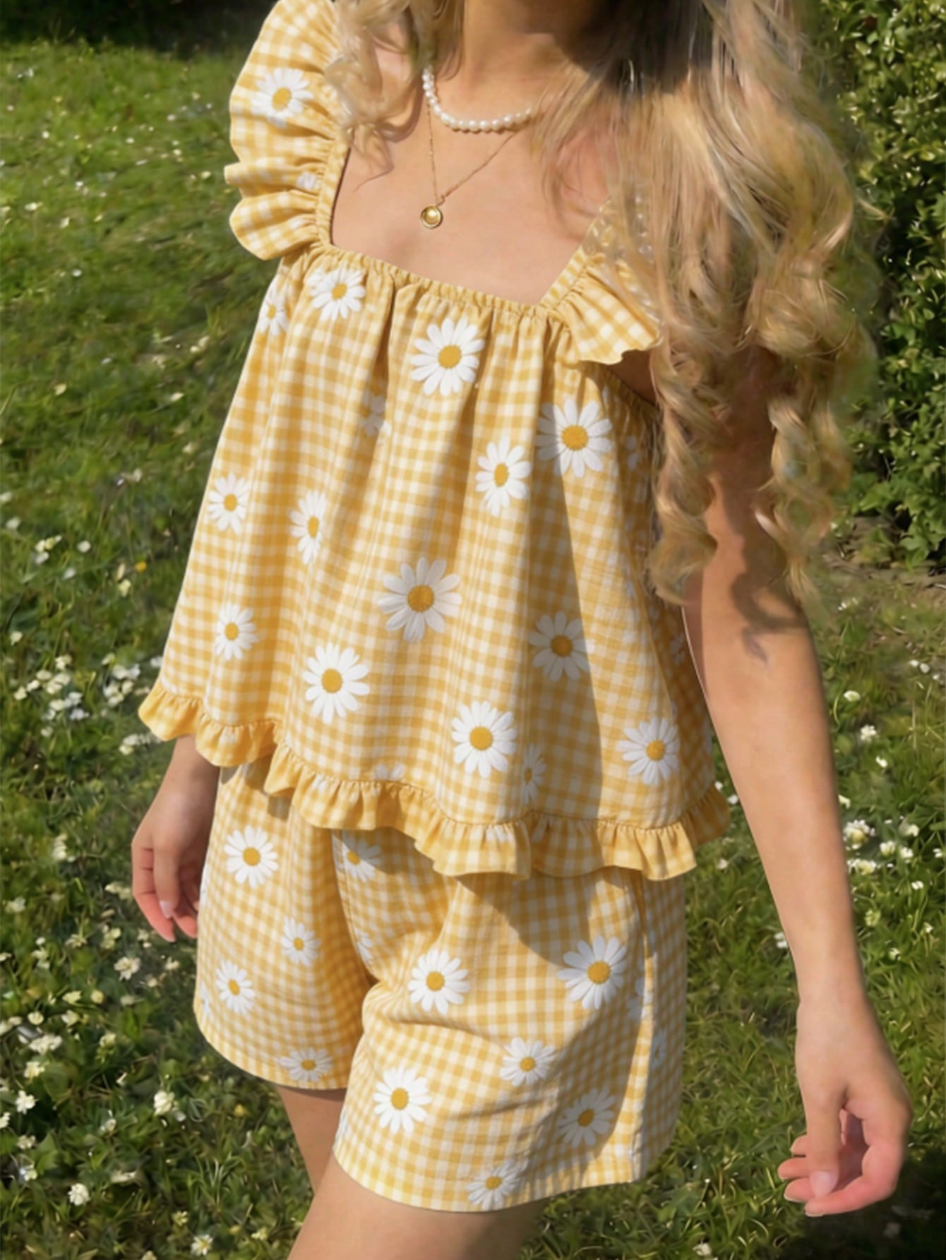 Tween girl wearing a blue and white striped sleeveless top featuring embroidery details and ruffle trim with matching shorts.