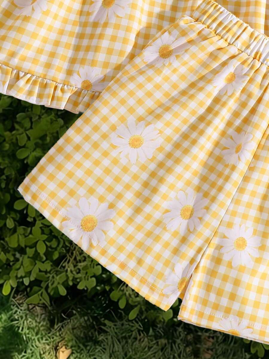Tween girl wearing a blue and white striped sleeveless top featuring embroidery details and ruffle trim with matching shorts.