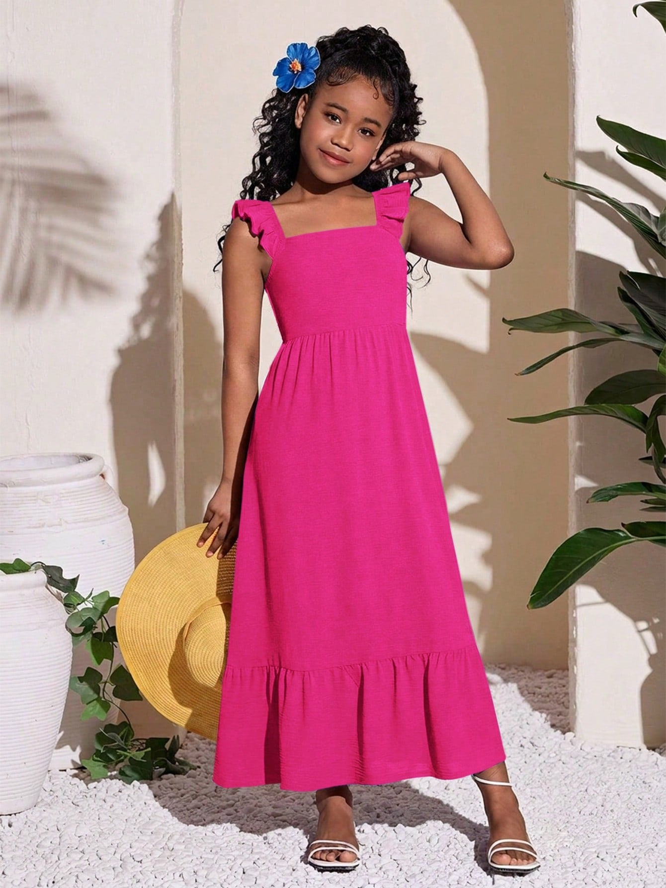 Blue floral print long vacation dress for tween girls featuring an A-line high waist silhouette with ruffle details and spaghetti straps.