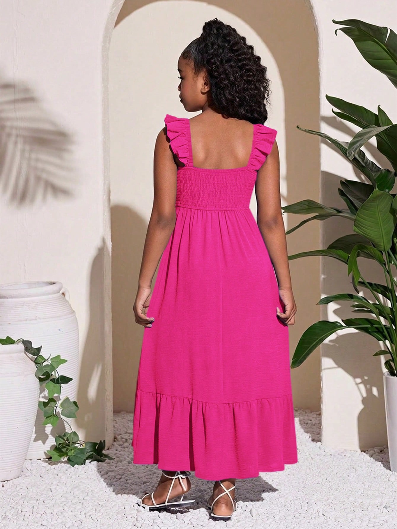 Tween girl multicolor floral vacation dress with square neck, ruffle details, shirred bodice, sleeveless A-line shape, high waist, and flounce hem.