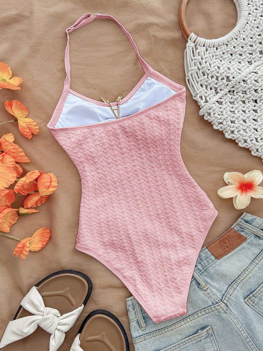 Pink textured halter one-piece swimsuit for tween girls with V-neck, tie strap, starfish and shell tassel accents, and lined body.