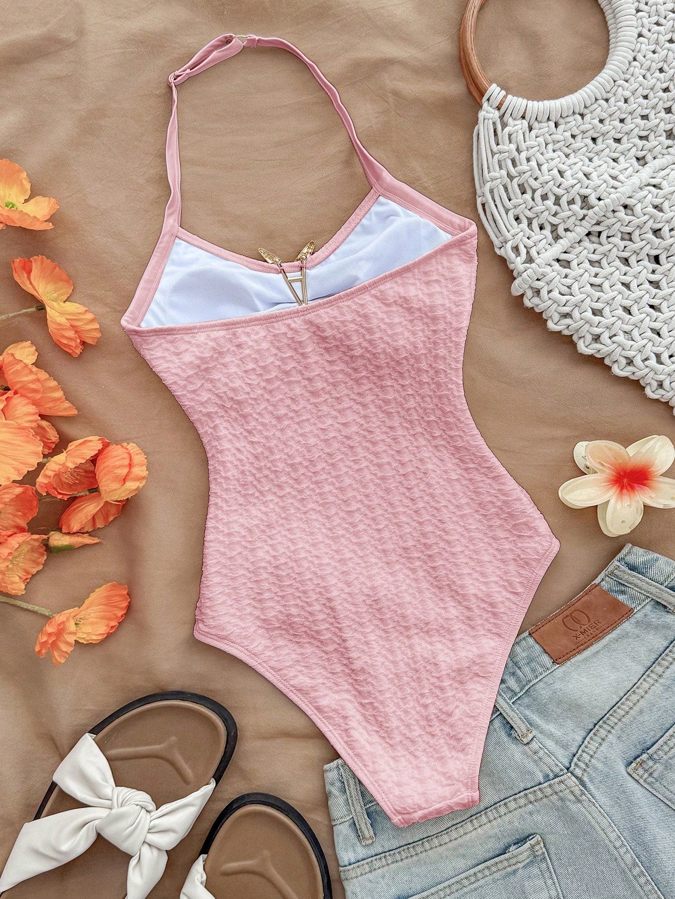 Pink textured halter one-piece swimsuit for tween girls with V-neck, tie strap, starfish and shell tassel accents, and lined body.