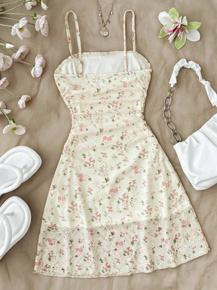 Tween girl yellow mini sundress with large pink floral hibiscus print, spaghetti straps, high waist, flared hem, and sleeveless cami style for summer beach wear