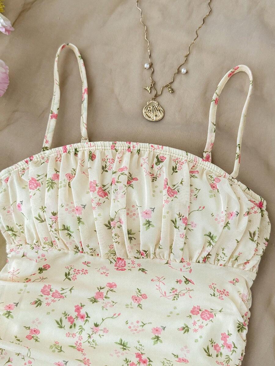 Tween girl yellow mini sundress with large pink floral hibiscus print, spaghetti straps, high waist, flared hem, and sleeveless cami style for summer beach wear
