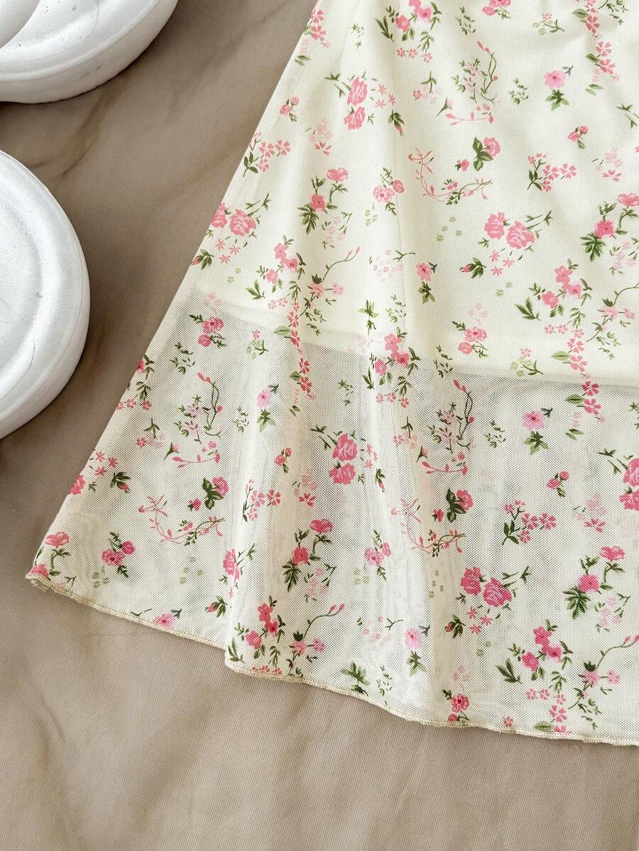 Tween girl yellow mini sundress with large pink floral hibiscus print, spaghetti straps, high waist, flared hem, and sleeveless cami style for summer beach wear