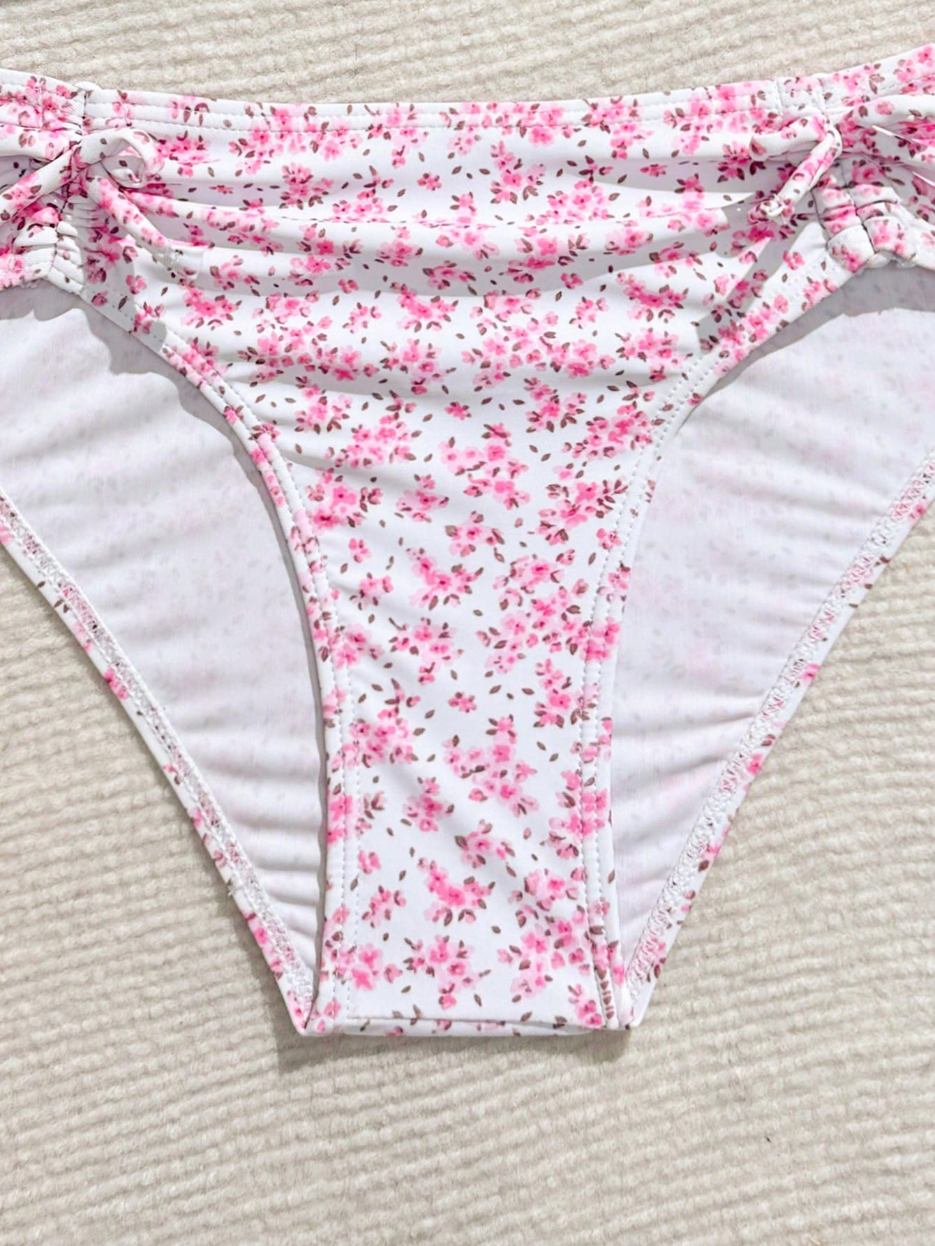 Tween girls 2-piece ditsy floral bikini set featuring a spaghetti strap top with center string detail and matching bottoms with side strings, designed for swimming, vacation, and summer wear.