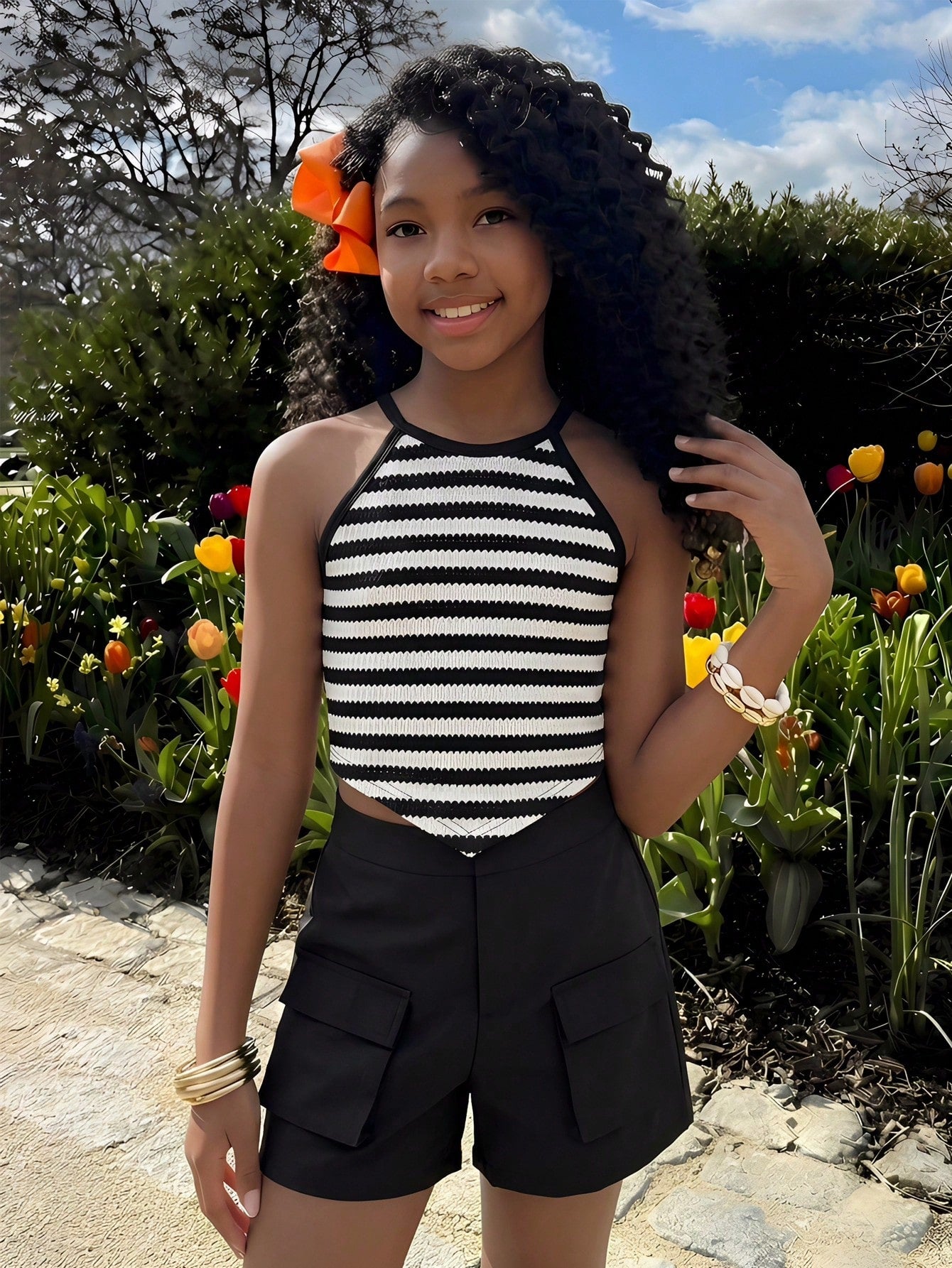 Girls 2-piece vacation outfit set with sleeveless halter knit crop top and graphic cargo shorts.