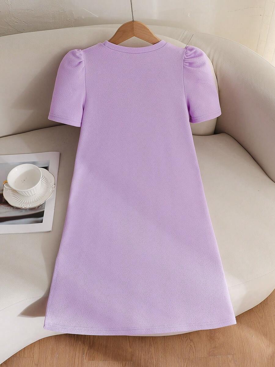Tween girls apricot short-sleeve pleated smock dress with 3D bow decor and round neckline.