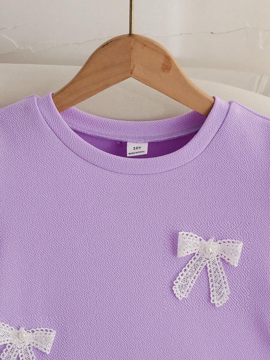 Tween girls apricot short-sleeve pleated smock dress with 3D bow decor and round neckline.