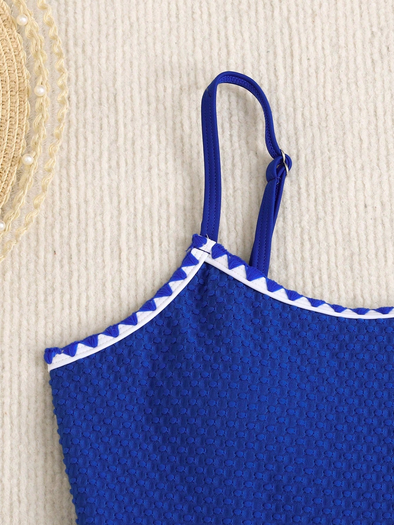 Blue colorblock one-piece swimsuit for tween girls with all-over print, contrast piping, spaghetti straps, and lined high-stretch fabric for beach or pool wear.