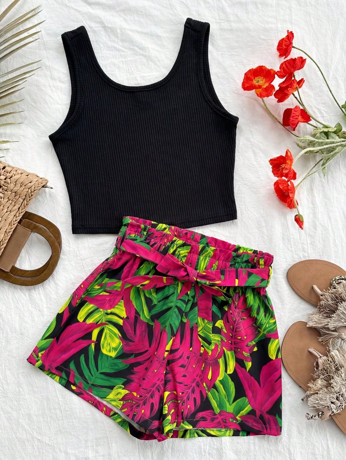 Tween girl wearing a casual 2-piece set featuring a black rib-knit scoop neck tank top and leopard print paperbag waist shorts with a matching belt.