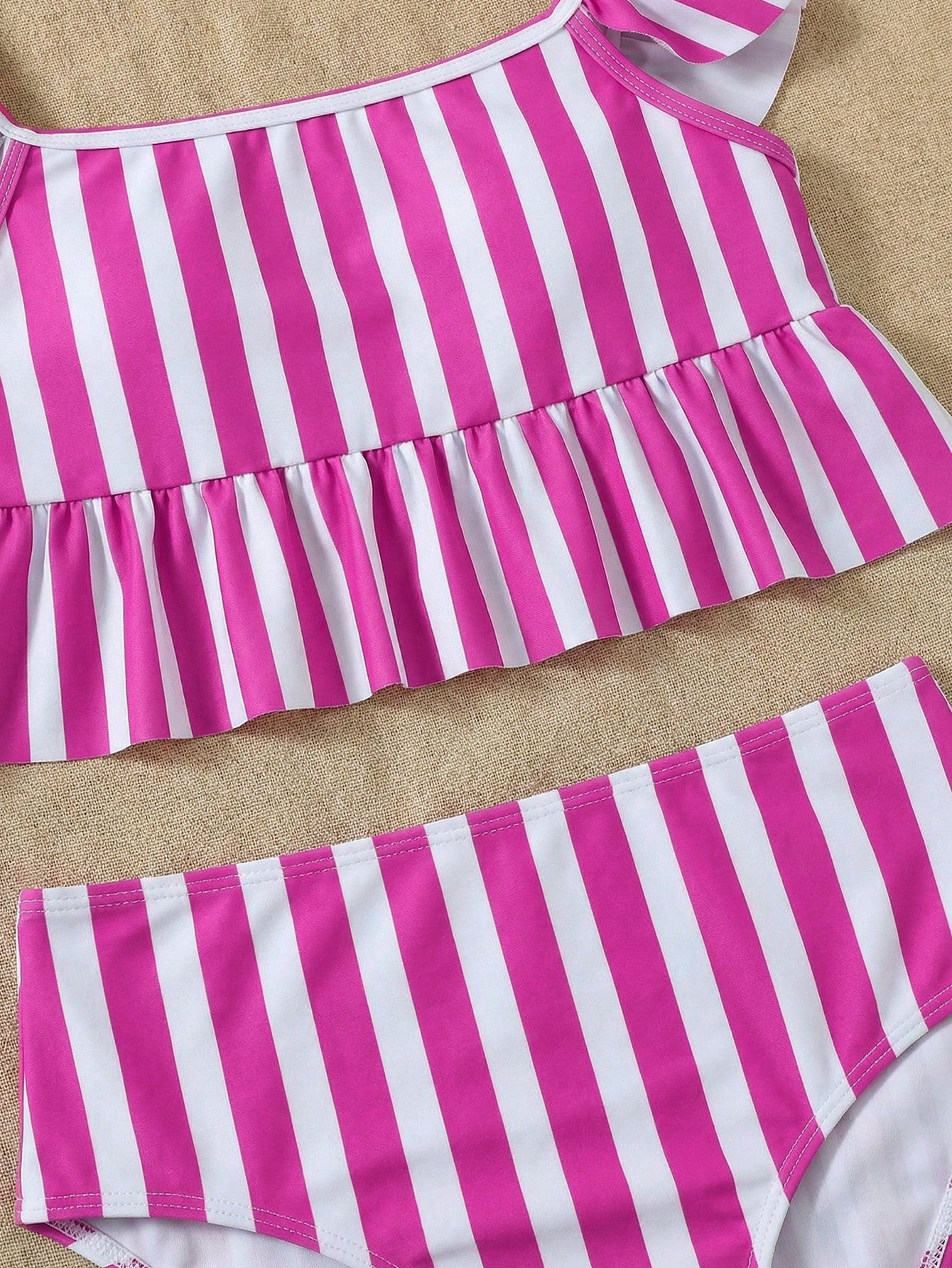 Girls striped tankini swimwear set with ruffle detail, square neckline, wireless top, and high-waist lined bottoms for beach and vacation wear.