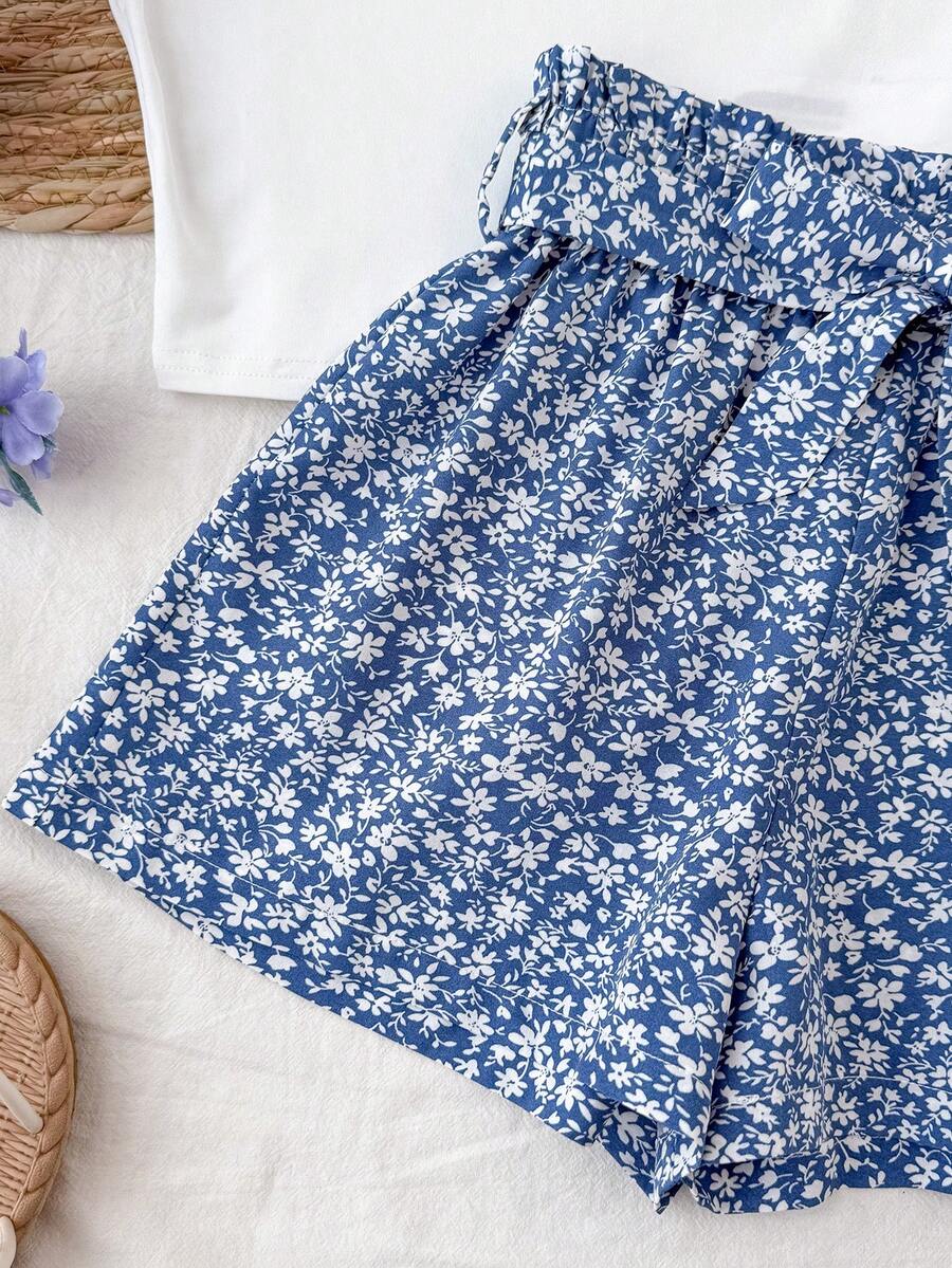 Tween girl summer two-piece outfit featuring a white scoop neck tank top and green ditsy floral print paperbag waist shorts with belt.