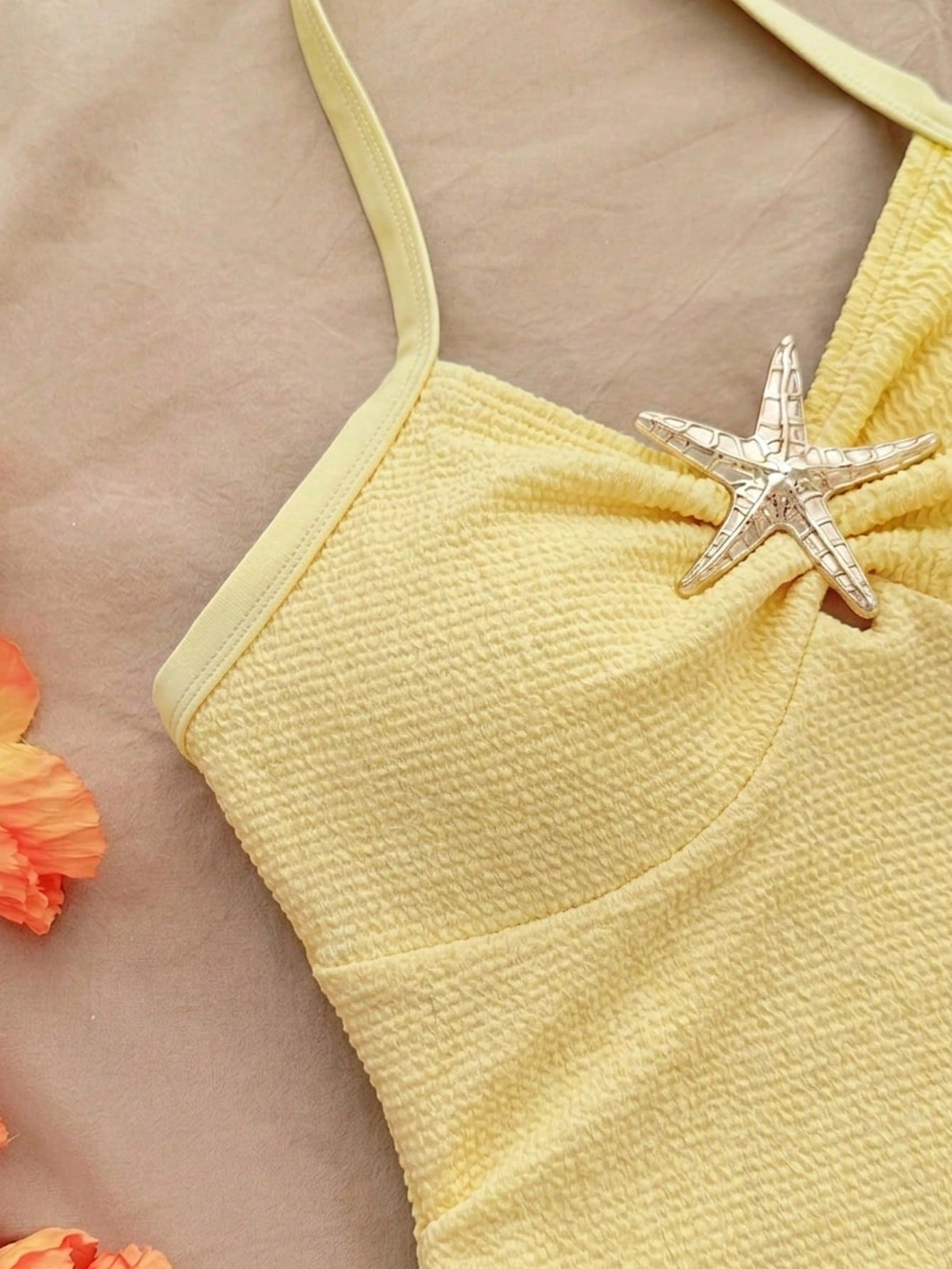 Pink textured halter one-piece swimsuit for tween girls with V-neck, tie strap, starfish and shell tassel accents, and lined body.