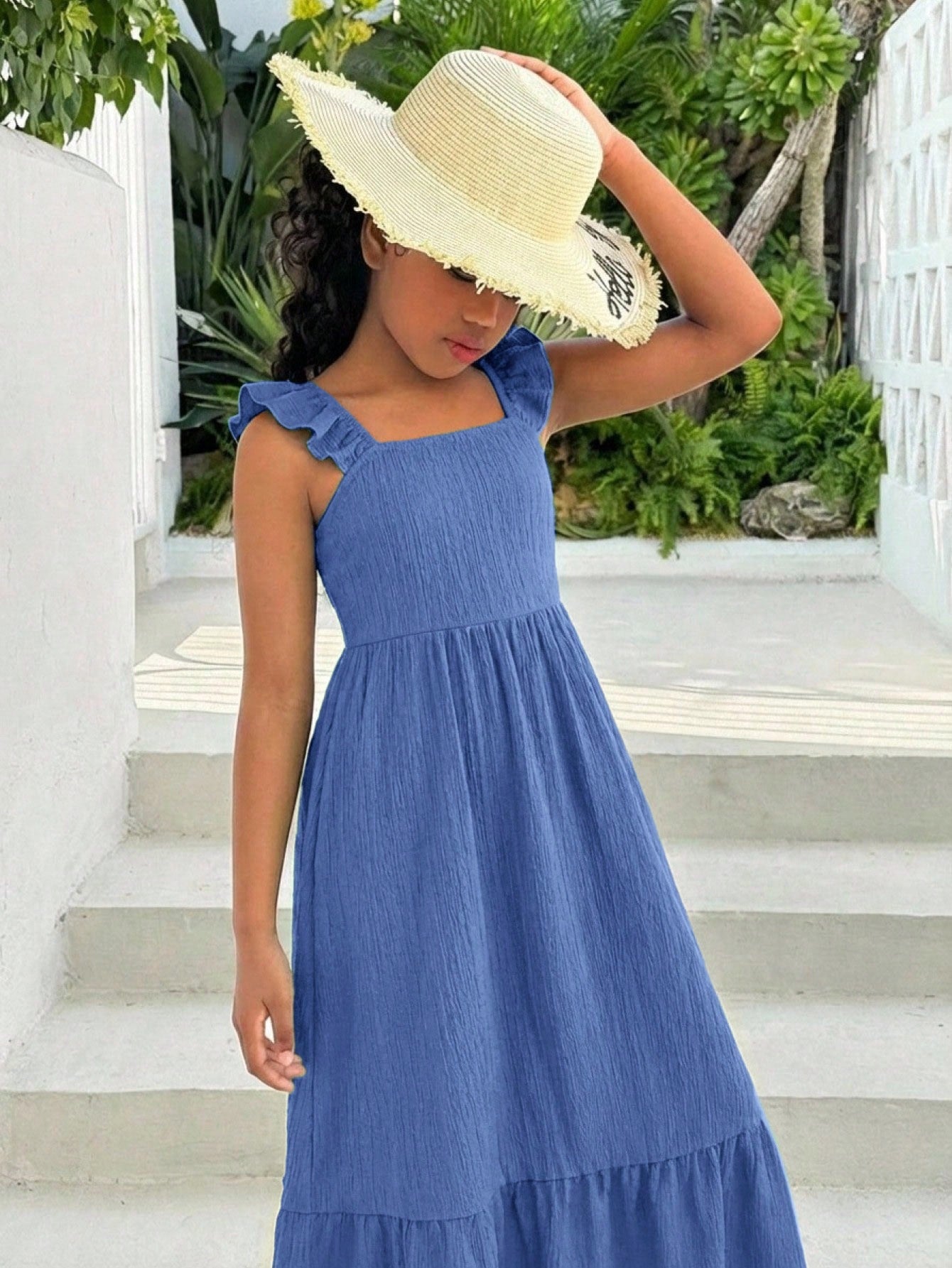 Tween girl multicolor floral vacation dress with square neck, ruffle details, shirred bodice, sleeveless A-line shape, high waist, and flounce hem.